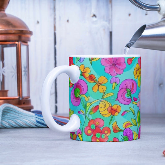 Colorful floral mug being filled with hot water from a kettle on a wooden surface.