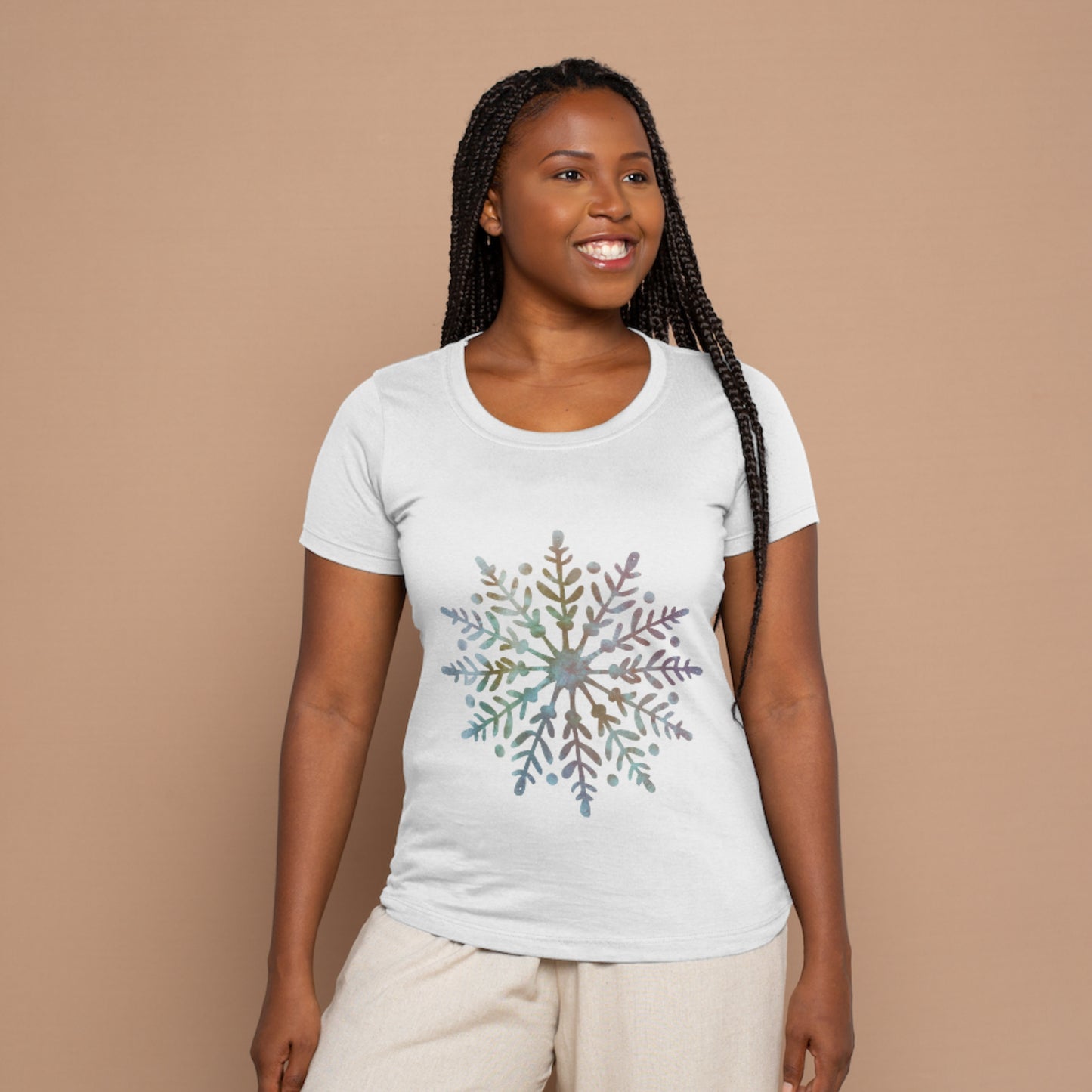Woman wearing a white t-shirt with a colorful snowflake design on a beige background