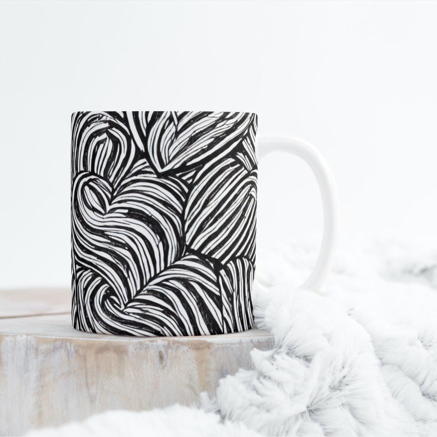 Black and white patterned pillow on a white surface with a blurred background