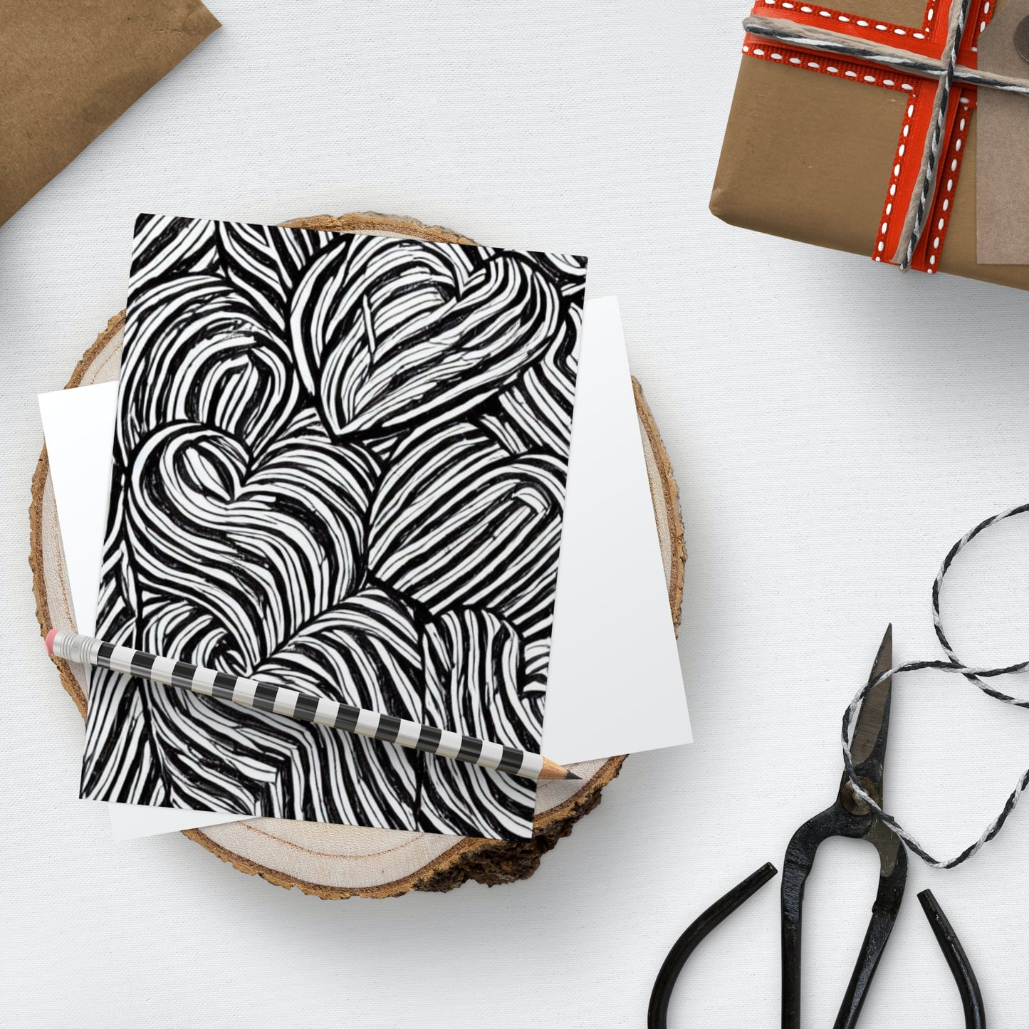 Black and white patterned notebook with scissors and paper on a white surface