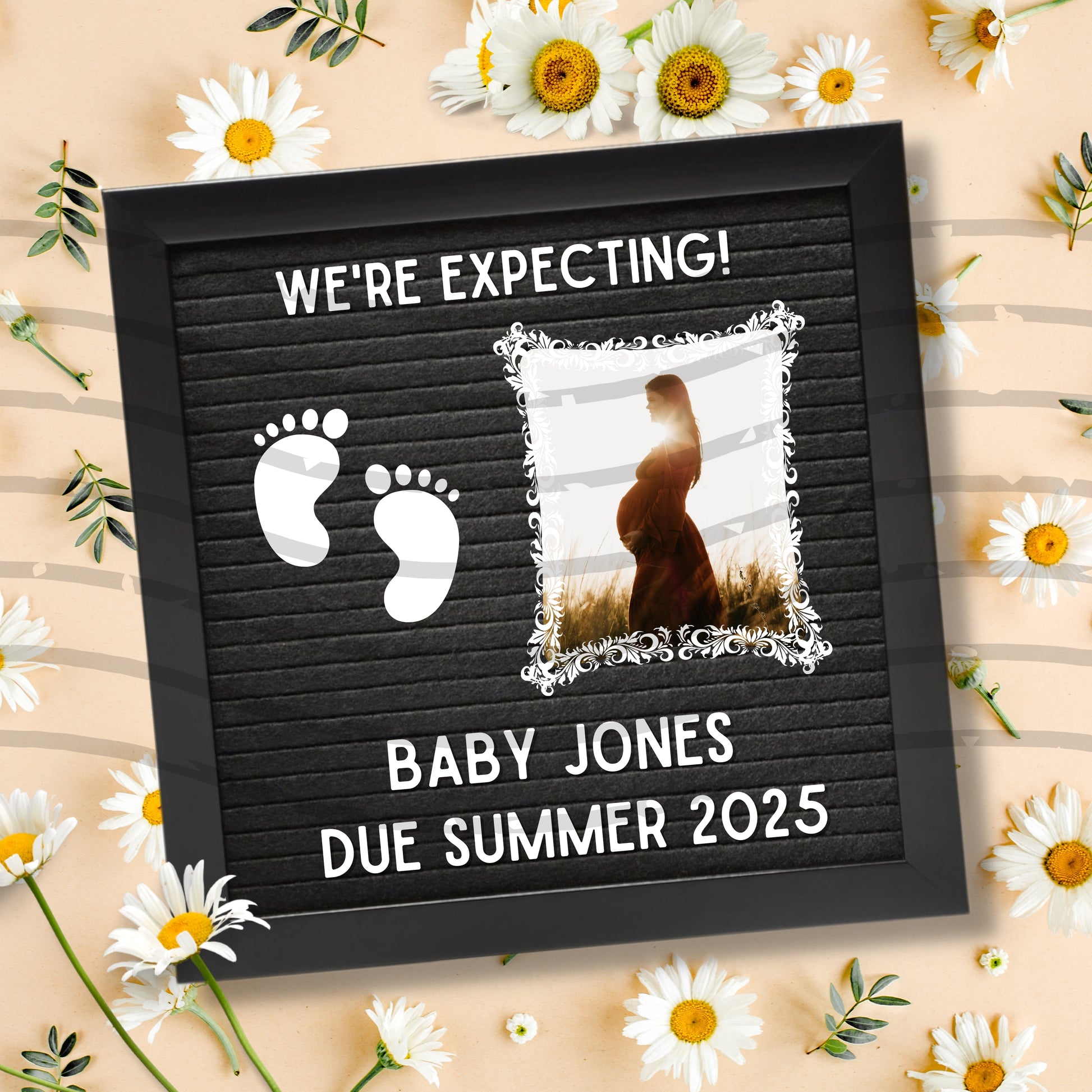 Felt letter board with baby announcement text and photo of a woman, surrounded by flowers on a beige background.