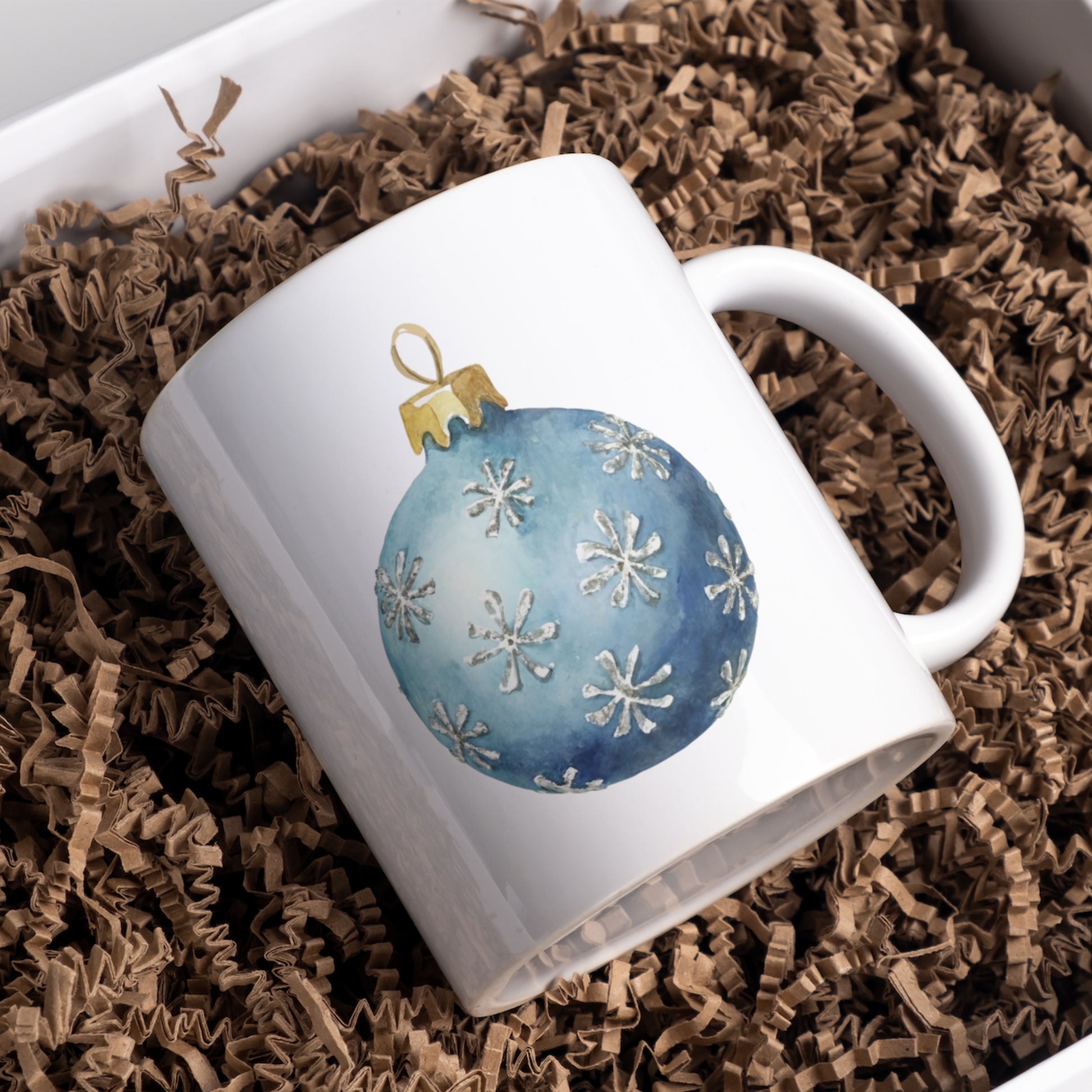 White mug with a blue ornament design on brown crinkled paper