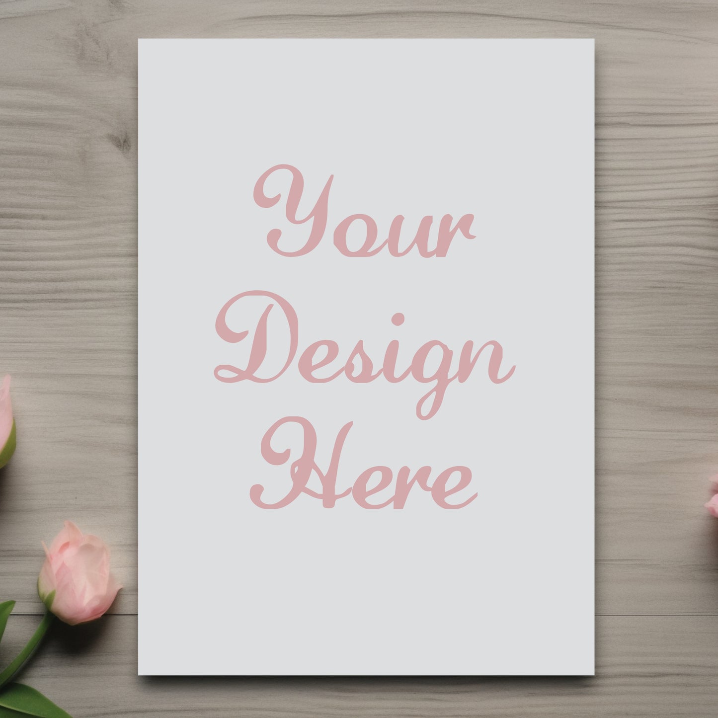Blank white card with 'Your Design Here' text on a wooden surface with pink roses.