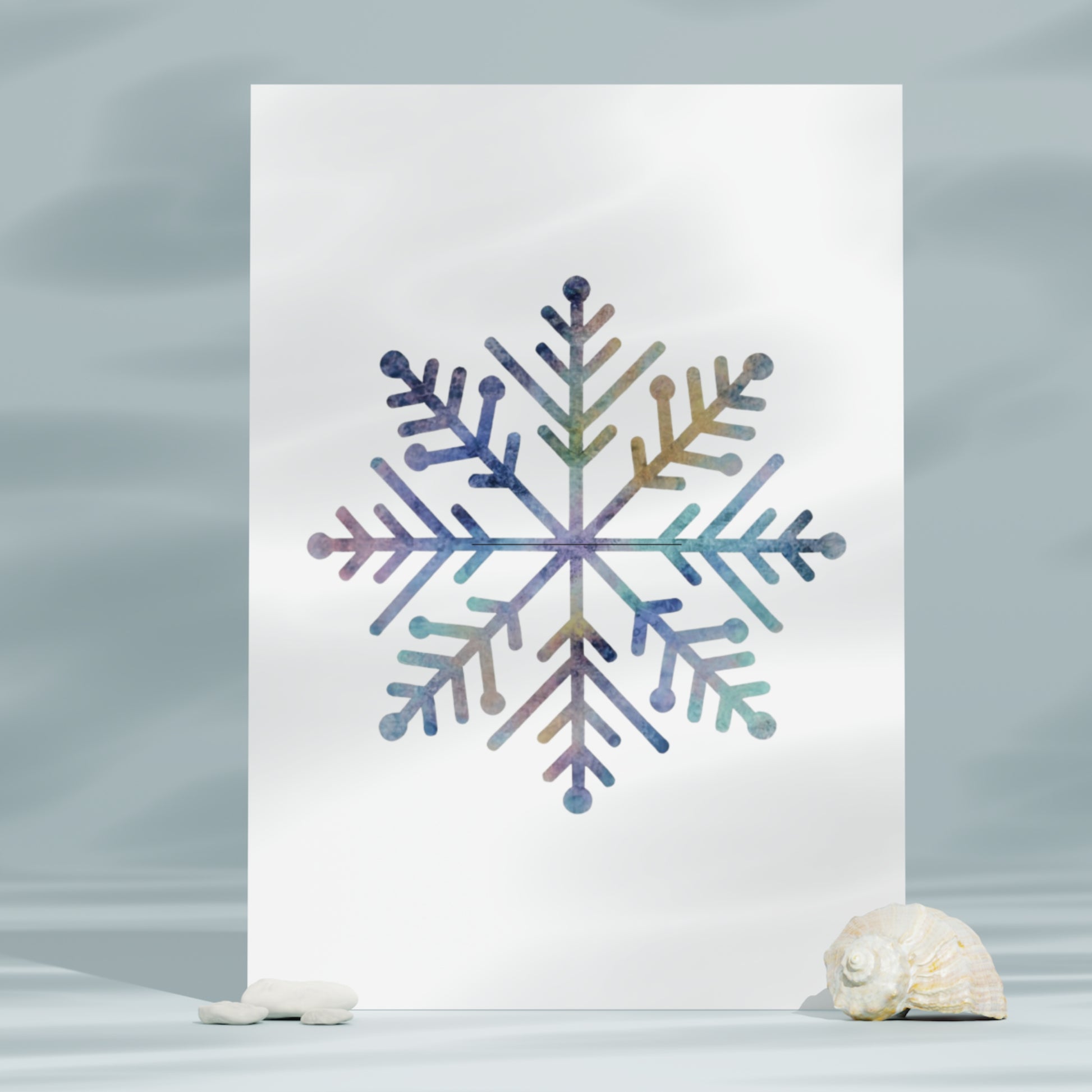 Colorful snowflake design on a white card with seashells on a gray background