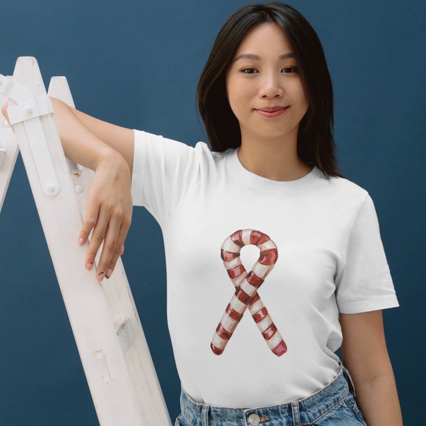 Woman wearing a white t-shirt with a candy cane design against a blue background