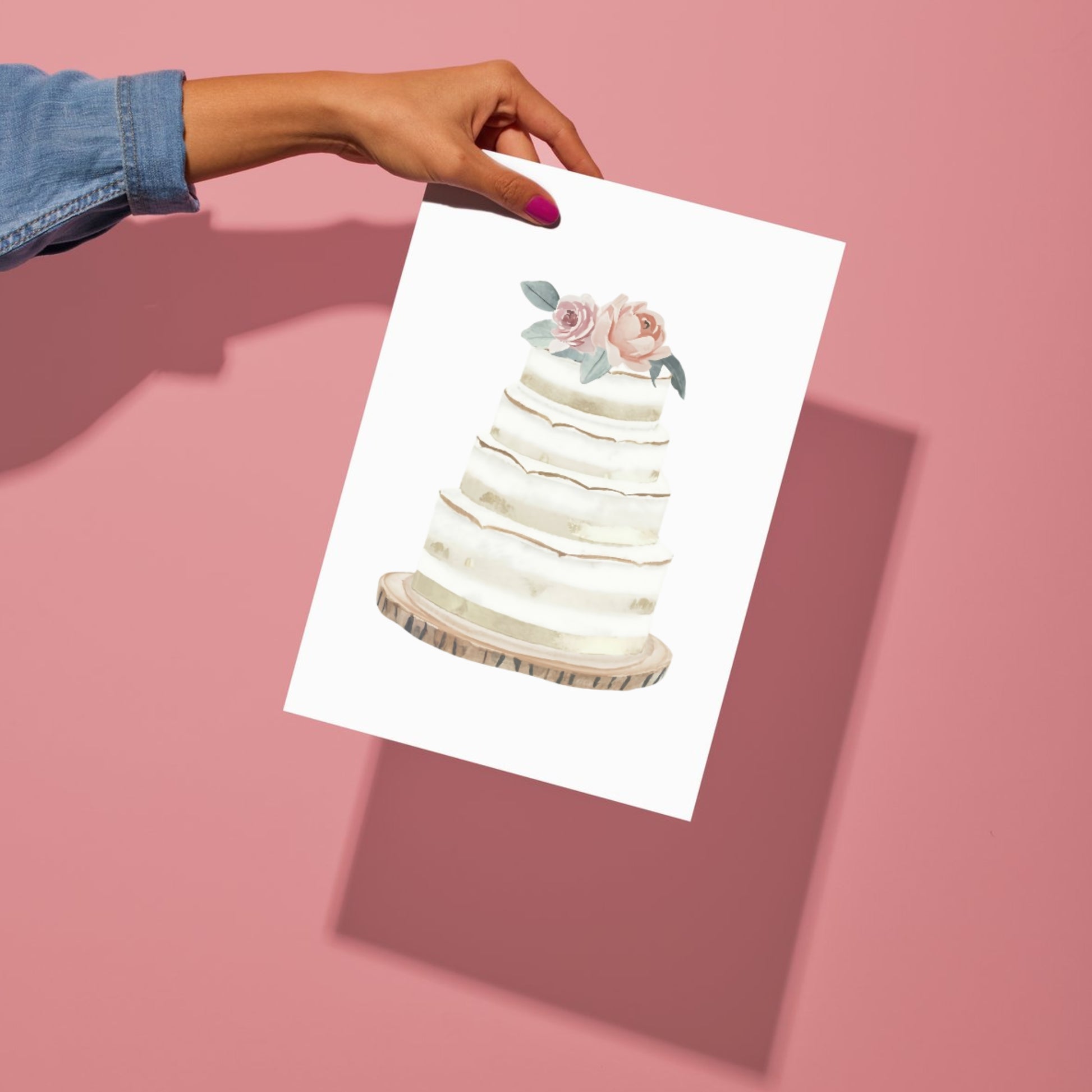 Hand holding a card with a cake illustration on a pink background
